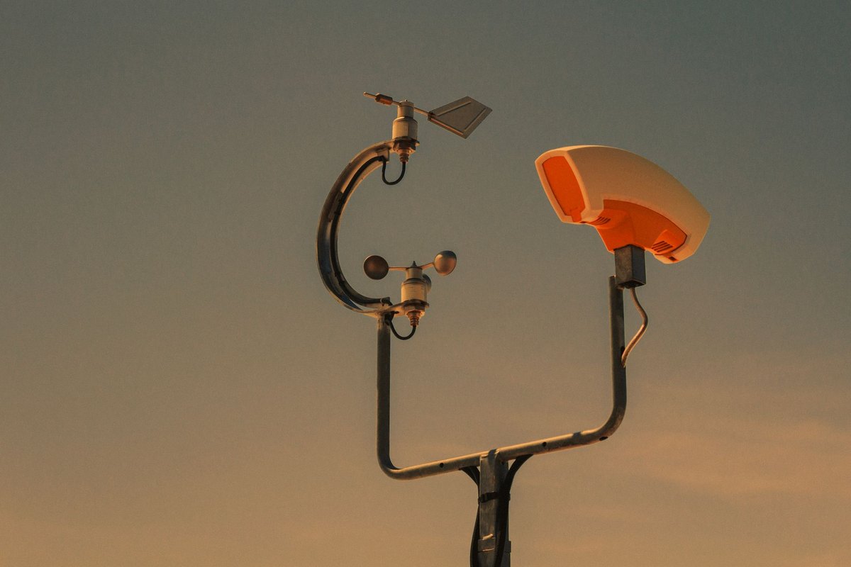 An industrial weather station sensor used for collecting environmental data at a renewable energy project site.